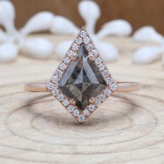 a brown diamond ring sitting on top of a piece of wood