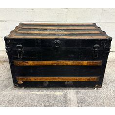 an old trunk is sitting on the sidewalk