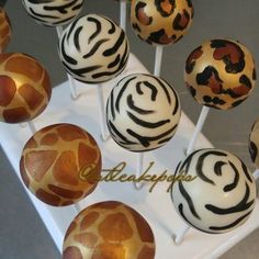 cake pops with zebra print on them sitting on a white tray