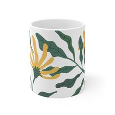 a white mug with yellow and green leaves on it