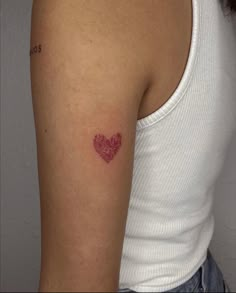 a woman with a heart tattoo on her arm