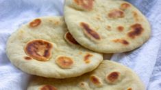 three pita breads sitting on top of a white towel next to each other