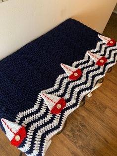 a crocheted tablecloth with red, white and blue stars on it sitting on a wooden floor