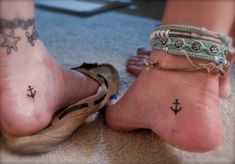 a woman's foot with an anchor tattoo on her ankle and two other feet