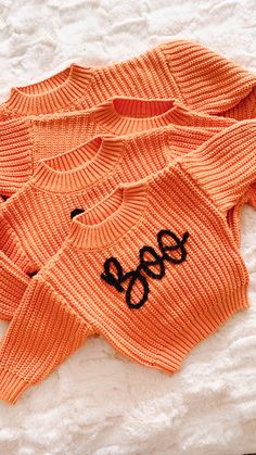 an orange sweater with the word boo spelled on it