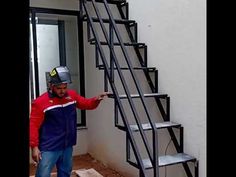 a man wearing a helmet standing next to a set of stairs