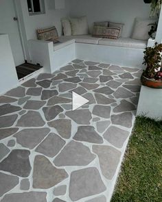 an outdoor patio with stone flooring and seating area