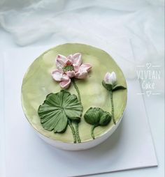 there is a cake decorated with flowers and leaves on the plate, it looks like water lilies