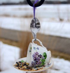 a tea cup and saucer hanging from a hook