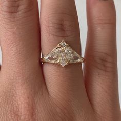 a woman's hand with a yellow gold ring on top of it and a diamond in the middle