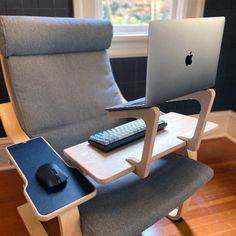 a laptop on a table with a keyboard and mouse in front of it, next to a chair