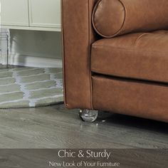 a brown leather couch sitting on top of a wooden floor next to a white cabinet