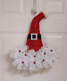 a door hanger with a santa claus hat on it's head and white tulle