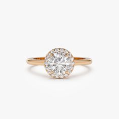 a yellow gold engagement ring with a round diamond center