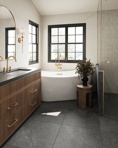 a bathroom with a tub, sink and large window