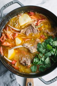 a pot filled with meat and vegetables on top of a table