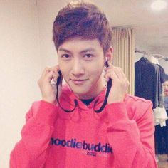 a young man in a red hoodie is talking on his cell phone