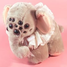 a small stuffed animal on a pink background