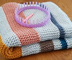 a close up of a knitted blanket with a clock on the front and side