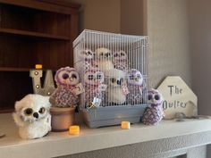 several stuffed animals are sitting on a mantle next to a birdcage and candles