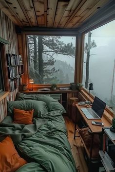 a bed sitting in a bedroom under a window next to a desk with a laptop on it