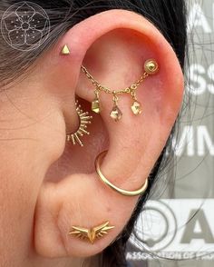 a woman wearing gold ear piercings with two different designs