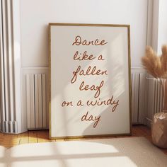 there is a sign that says dance like a fallen leaf on a windy day next to a potted plant