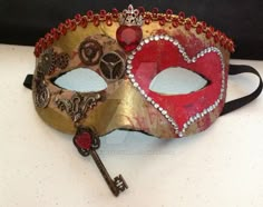 a red and gold mask with keys attached to it