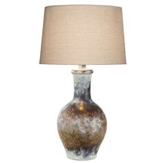 a brown and white vase lamp with a beige shade on the top, sitting in front of a white background