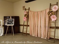 a room with two ladders and pink flowers on the wall next to a sign