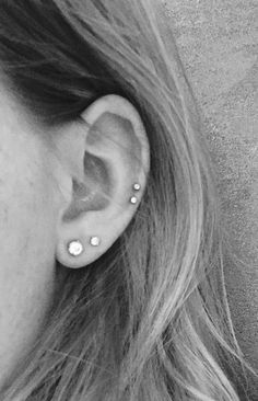 a close up of a person with ear piercings on their ears and behind them is a black and white photo