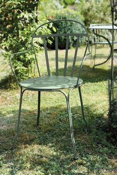 two green metal chairs sitting in the grass