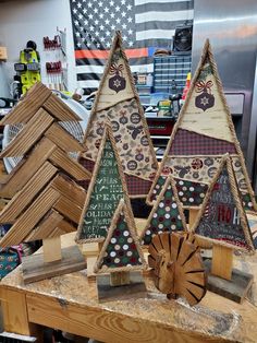 three wooden christmas trees sitting on top of a table next to other woodworking items