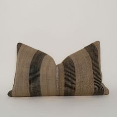 a brown and black striped pillow sitting on top of a white table