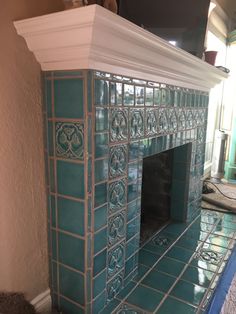 a fireplace with blue tiles and white trim