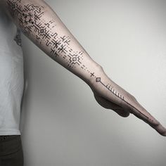 a person with a tattoo on their arm holding up a piece of paper in the air