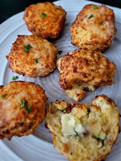 several crab cakes on a white plate with parsley