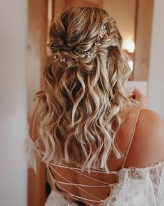 the back of a woman's head wearing a wedding dress and hair combs