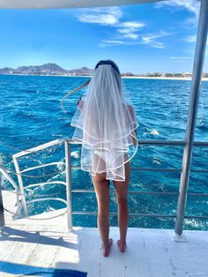 a woman wearing a veil on top of a boat