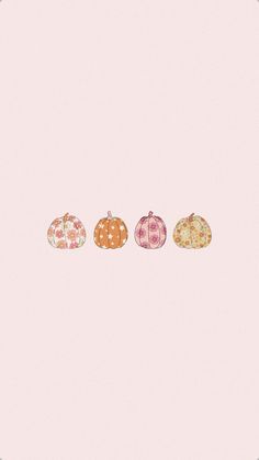 three pumpkins sitting side by side on a pink background