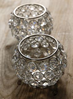 three crystal candlesticks sitting on top of a wooden table