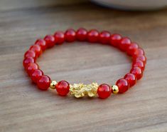 "This is Pure Real 24 Karat Gold Pixiu/Natural Carnelian Gold Pixiu Piyao( less than 1 g ) - Approximately 13mm x 6mm 14 karat Gold Beads Round - Approximately 3mm Carnelian Beads - Approximately 6mm Hallmark/Stamp 999 for 24k Gold (PIXIU) Please select bracelet size. All are handmade with care .Strung on heavy duty stretchy/elastic. Products and photo may differ. Bracelet Comes with Storage Bag & Box How to Determine Bracelet Size: Step 1: Measure your wrist just below the wrist bone, where Red Bracelet, Red Carnelian, Lucky Bracelet, 24 Karat Gold, Tiger Eye Bracelet, Carnelian Beads, Red Bracelets, Yellow Gold Bracelet, Nature Bracelets