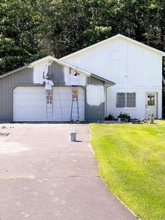 two men are painting the exterior of a house