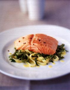 a white plate topped with pasta and salmon