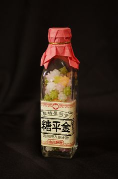 a bottle filled with lots of different types of food on top of a black surface