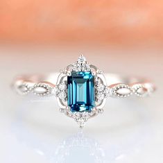 an engagement ring with a blue stone in the center and diamond accents around the band