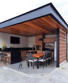 an outdoor kitchen and dining area is shown in this image, with the roof open