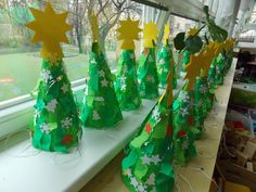 paper christmas trees are lined up on a window sill