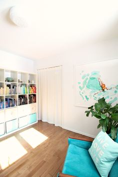 a living room filled with furniture and a book shelf next to a potted plant