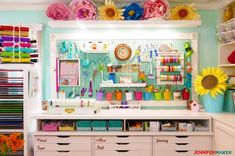 a sewing room with lots of crafting supplies on the wall and shelves above it